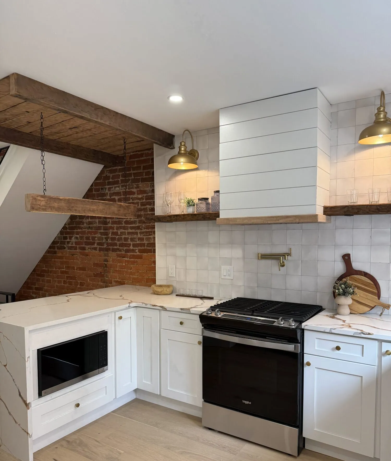 Modern kitchen with white cabinetry, open wood shelving, and dark tile backsplash