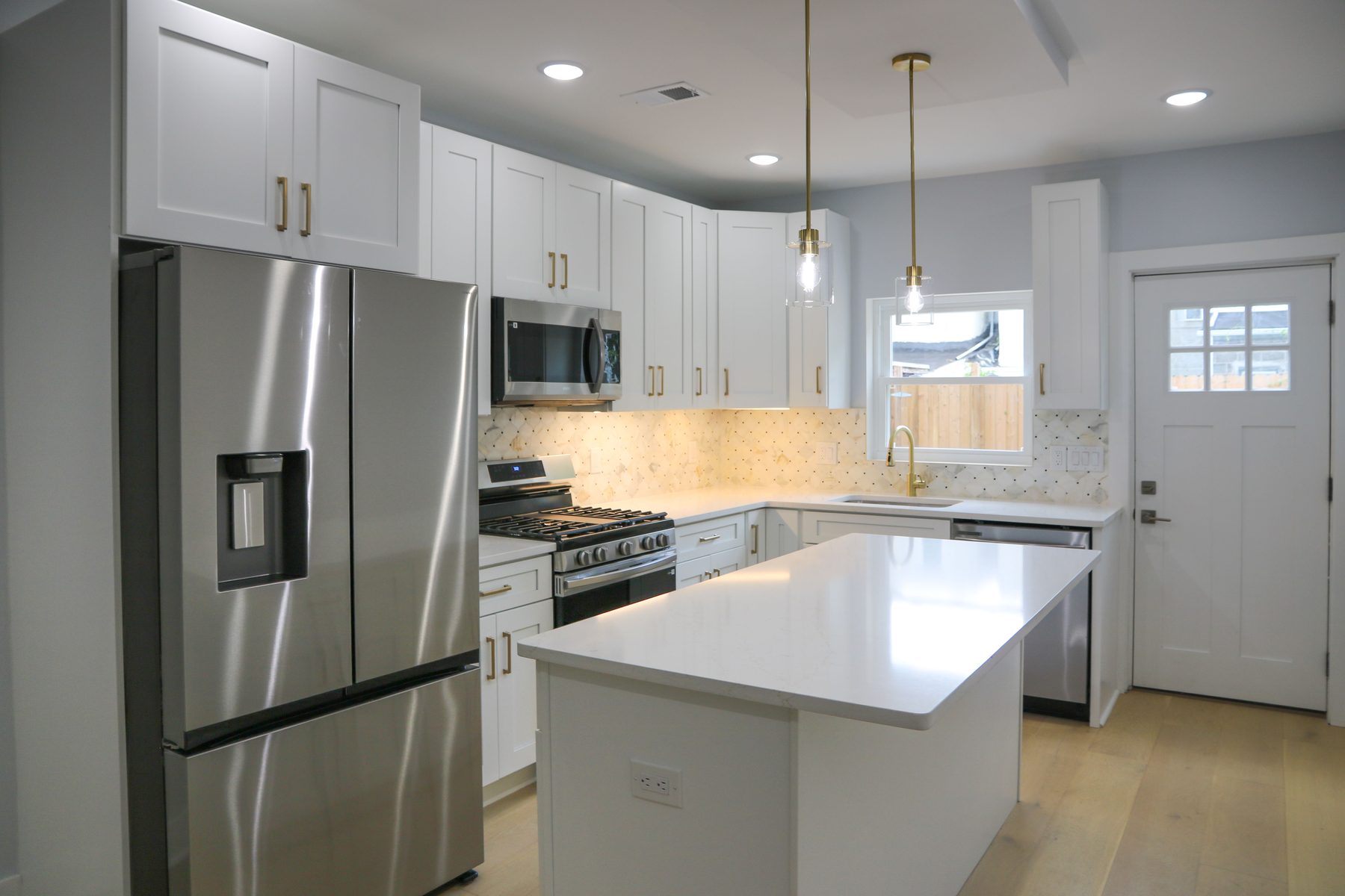Kitchen install featuring stone countertops and custom cabinetry