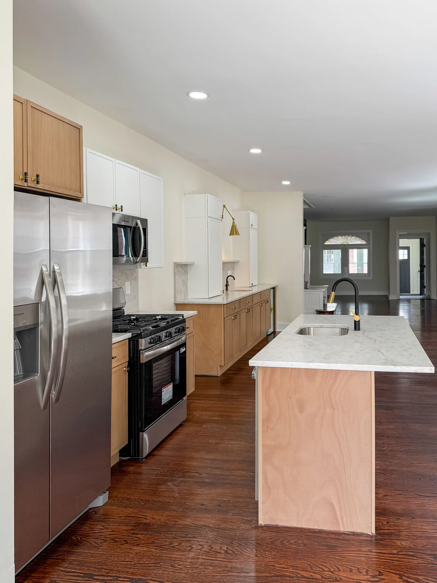 Maple kitchen with white uppers, island seating, and stainless appliances