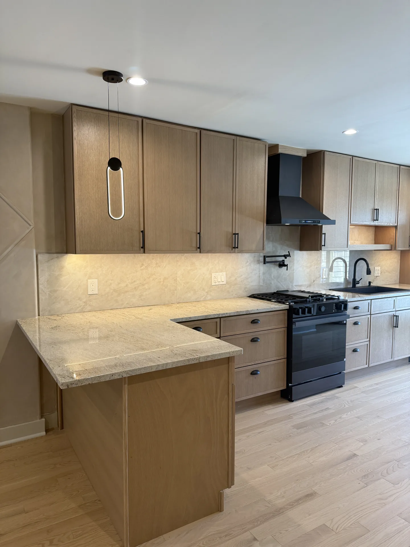 White oak kitchen with black hardware and natural quartzite countertops