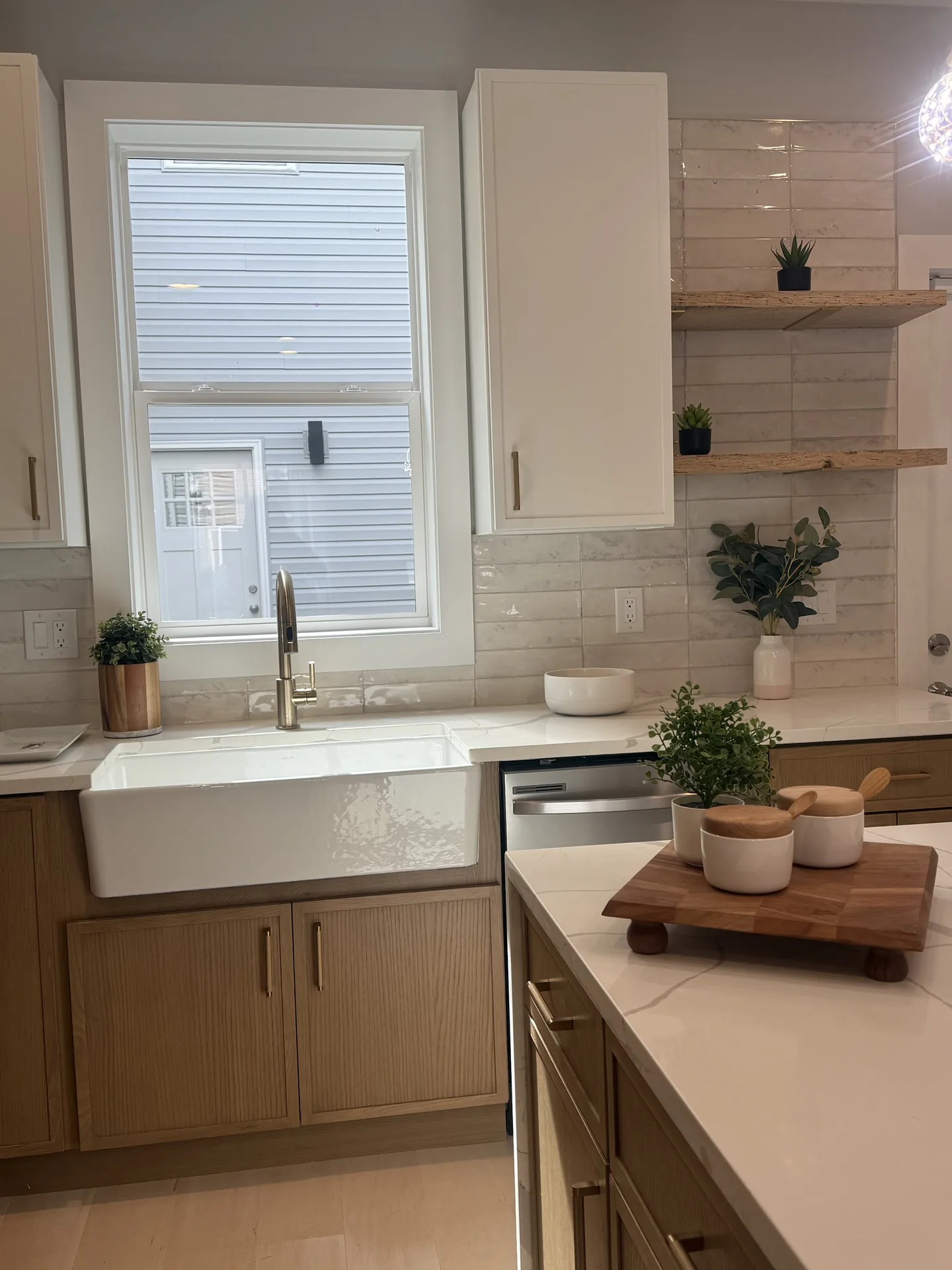 Farmhouse sink with open shelving and warm oak cabinets