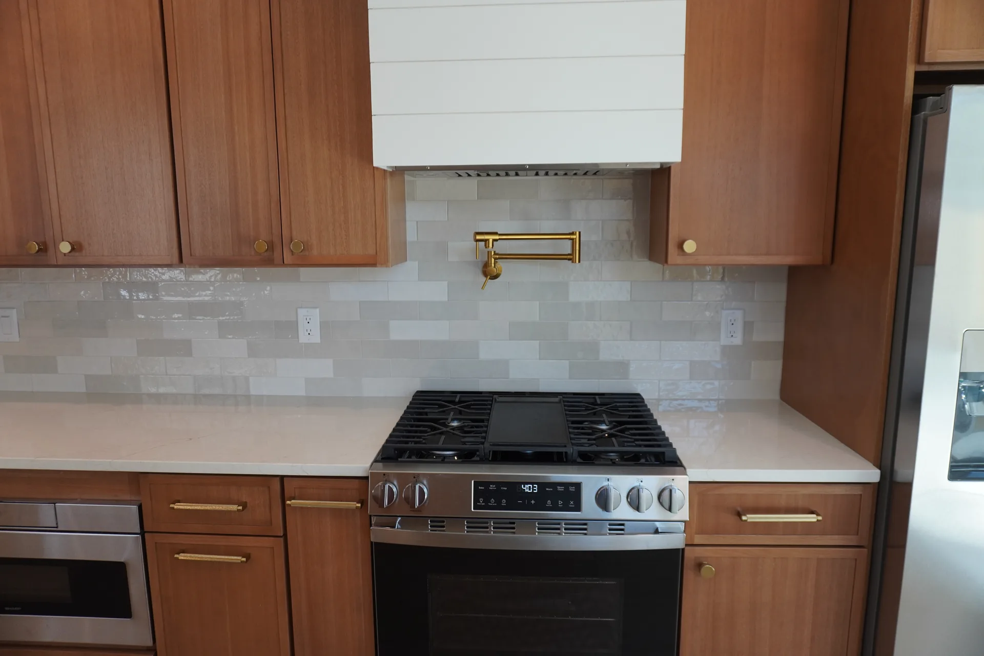 Gas range with pot filler, zellige tile backsplash, and custom hood
