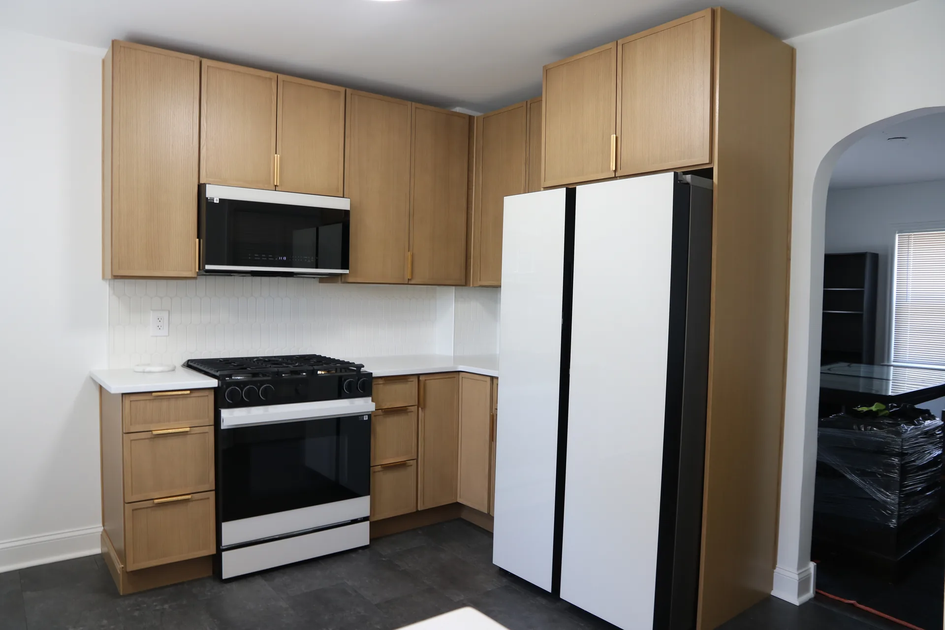 White oak cabinets with white appliances and matte quartz countertops