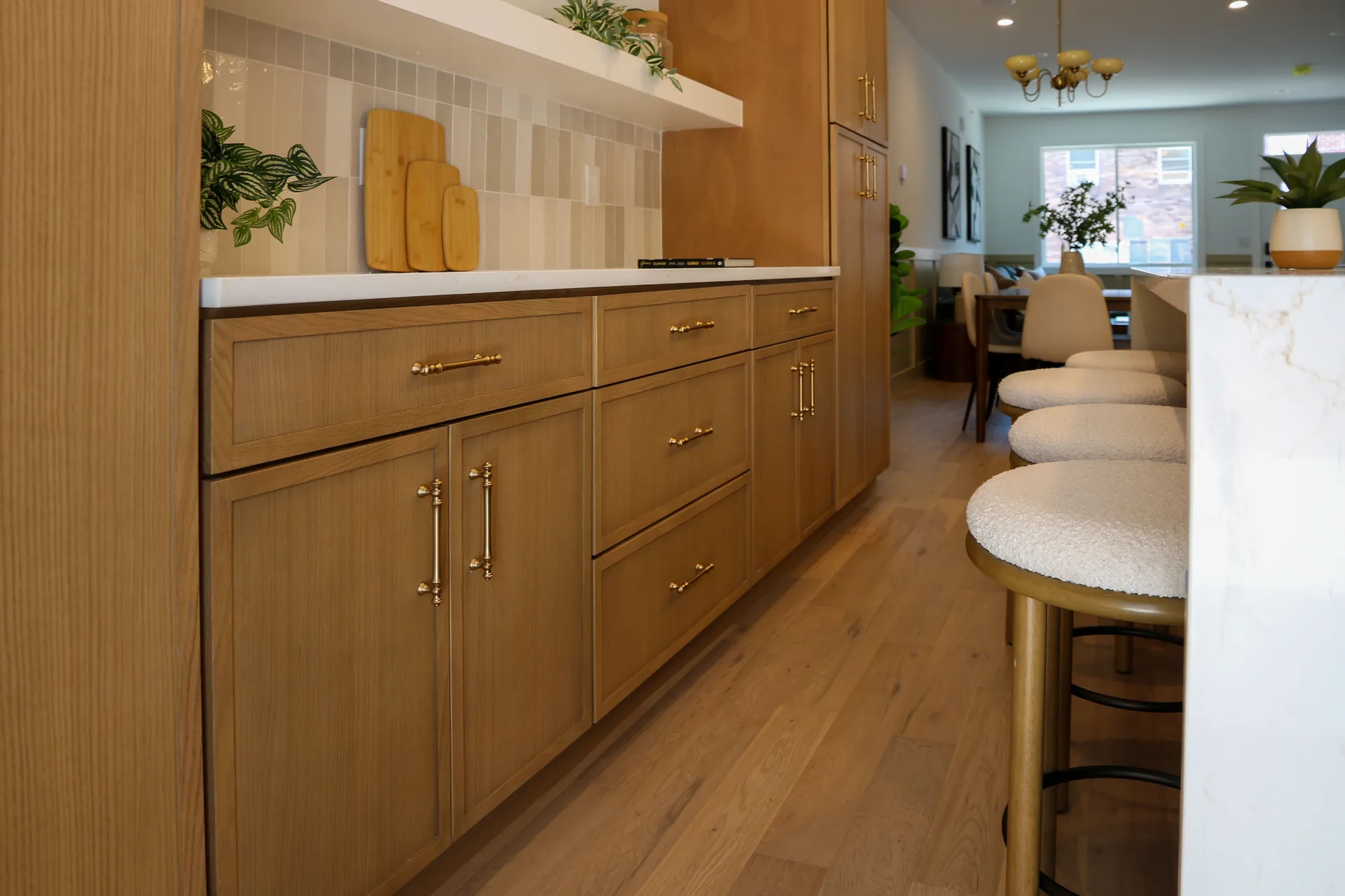 White oak cabinetry with brass hardware and island seating