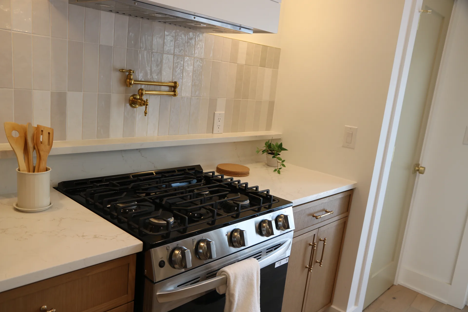 Stainless range with floating shelves and vertical stacked tile backsplash