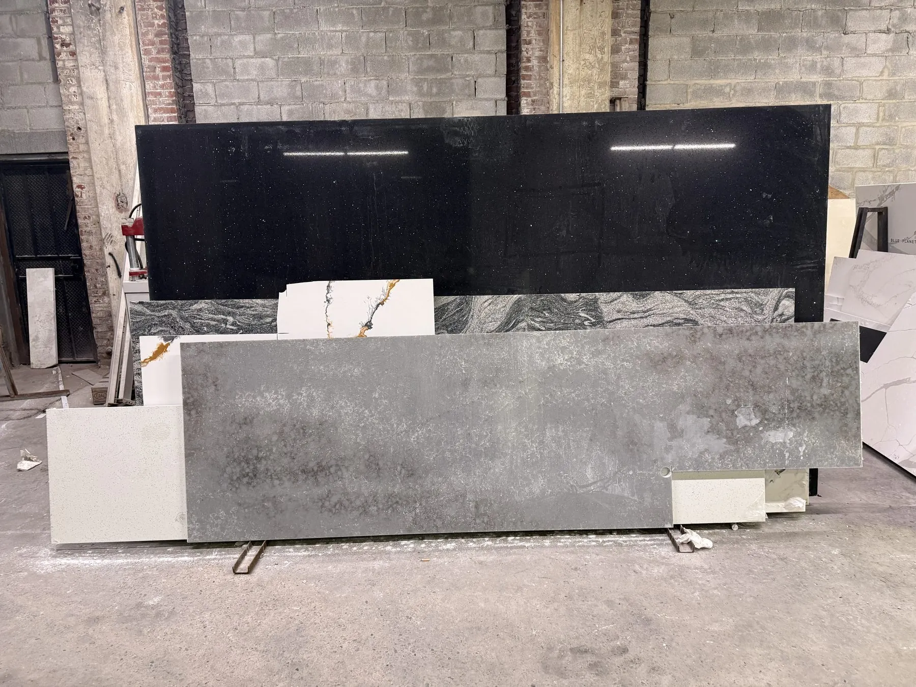 Black granite and gray quartz slabs displayed side by side